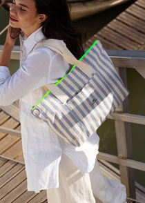 Bolso shopper de algodón orgánico con rayas azul marino y crema, destacando su cremallera en color amarillo flúor.